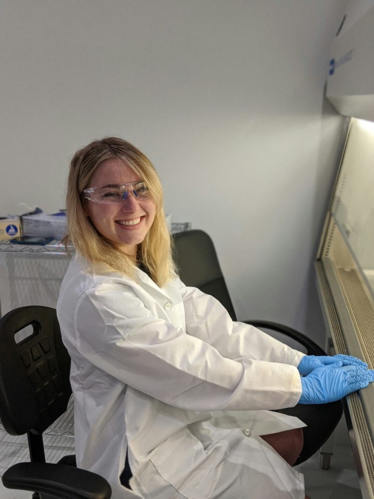 Mujer sonriente en bata de laboratorio